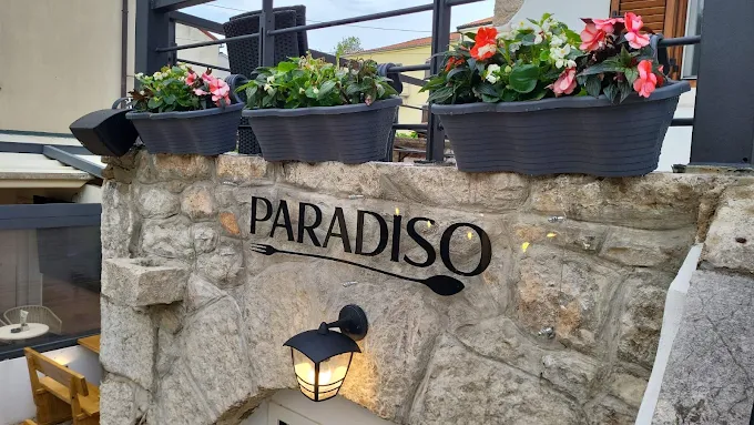 Kameni zid s natpisom Paradiso i cvijećem